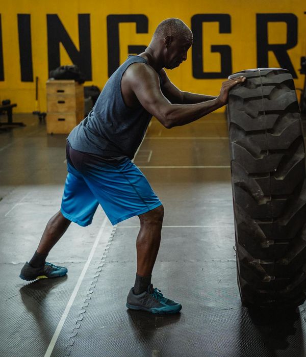 Athletic man performing a functional strength exercise in gym